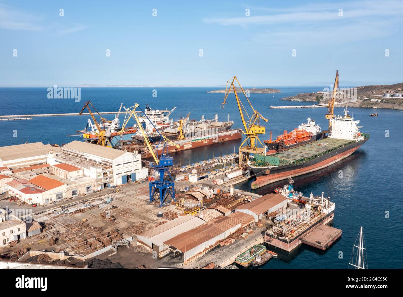 Isola di Syros, Grecia, Cicladi. Vista del drone aereo del porto e del cantiere navale di Neorion, stabilimento industriale di Ermoupolis, sfondo blu del cielo. Siros o Syra, Foto Stock