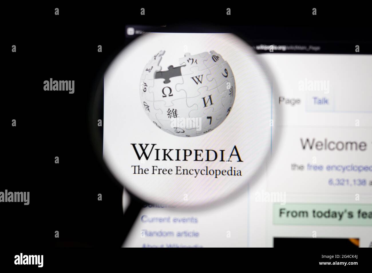 Wikipedia Company logo su un sito web visto su uno schermo del computer attraverso una lente di ingrandimento. Foto Stock