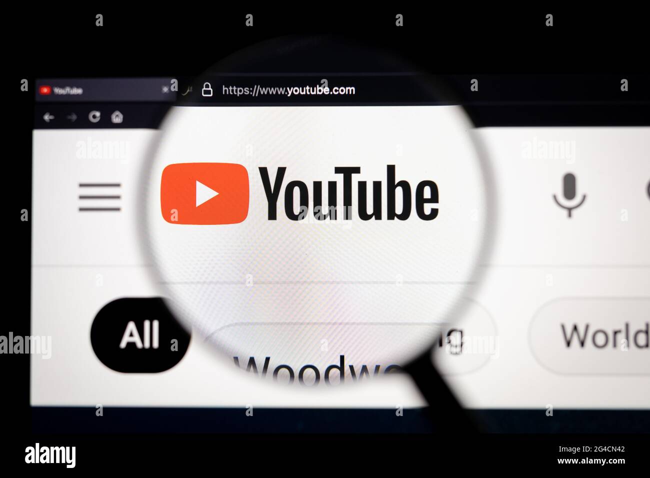 Logo della società YouTube su un sito Web, visualizzato sullo schermo di un computer tramite una lente di ingrandimento. Foto Stock
