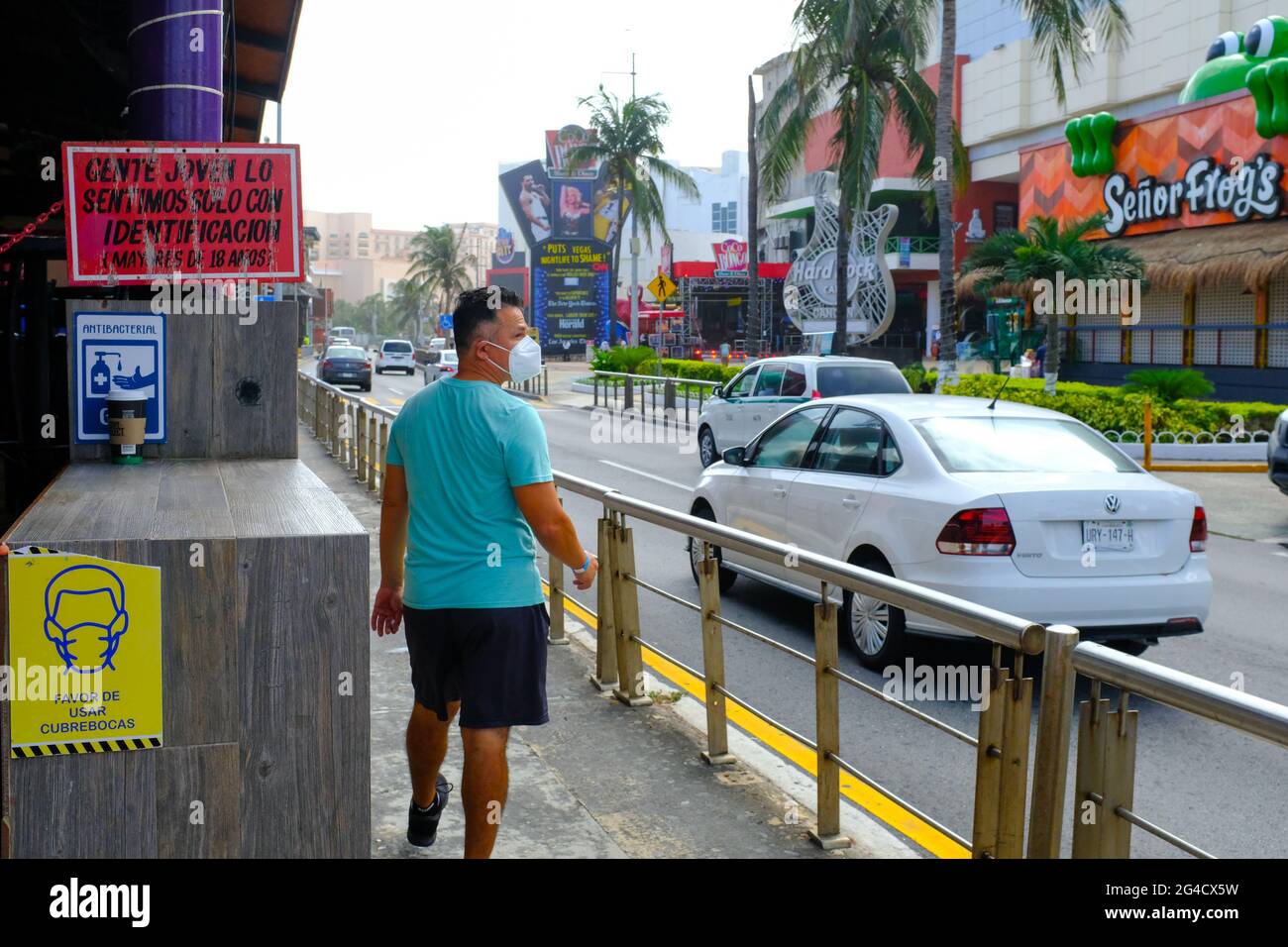 Uomo che indossa una maschera che cammina nella zona degli hotel di Cancun Messico durante la pandemia di Coronavirus Foto Stock