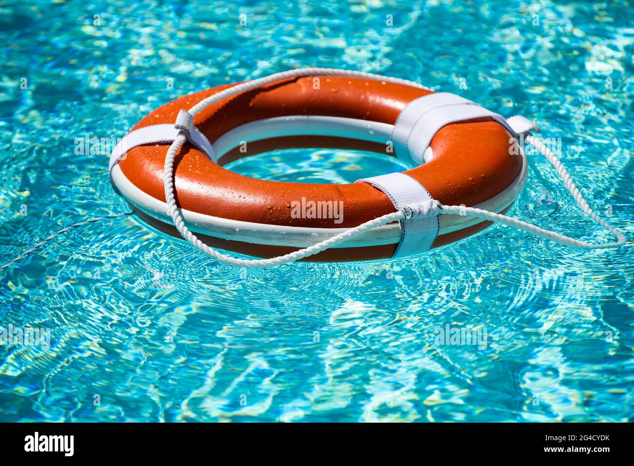 Cintura di sicurezza in mare o in piscina. Anello gonfiabile arancione che  galleggia in acqua blu. Boa di vita per proteggere e annegare di sicurezza  Foto stock - Alamy