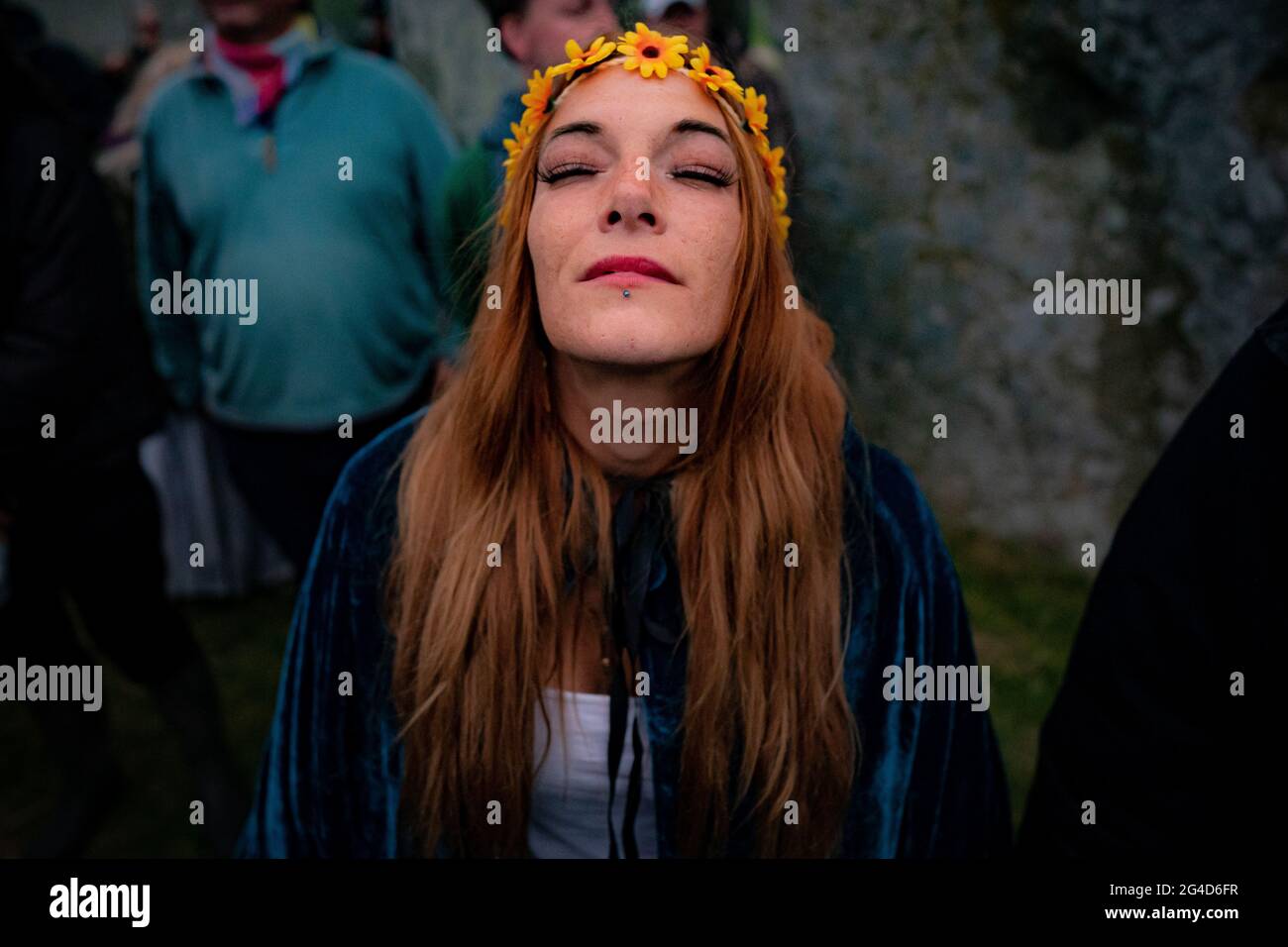 Una donna tace all'interno del cerchio di pietra durante il Summer Solstice a Stonehenge, dove alcune persone saltarono sopra la recinzione per entrare nel sito per guardare il sole sorgere all'alba della più lunga giornata nel Regno Unito. Le pietre sono state ufficialmente chiuse per le celebrazioni, che vedono enormi folle all'interno del cerchio, a causa dell'estensione del blocco del coronavirus. Data immagine: Lunedì 21 giugno 2021. Foto Stock