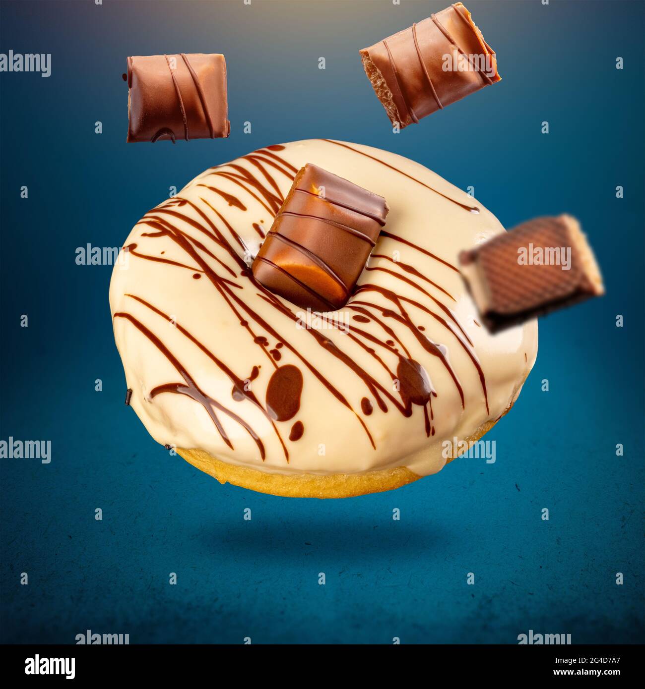 Concetto di cibo dolce volante con torta di ciambelle rotonda su sfondo blu Foto Stock