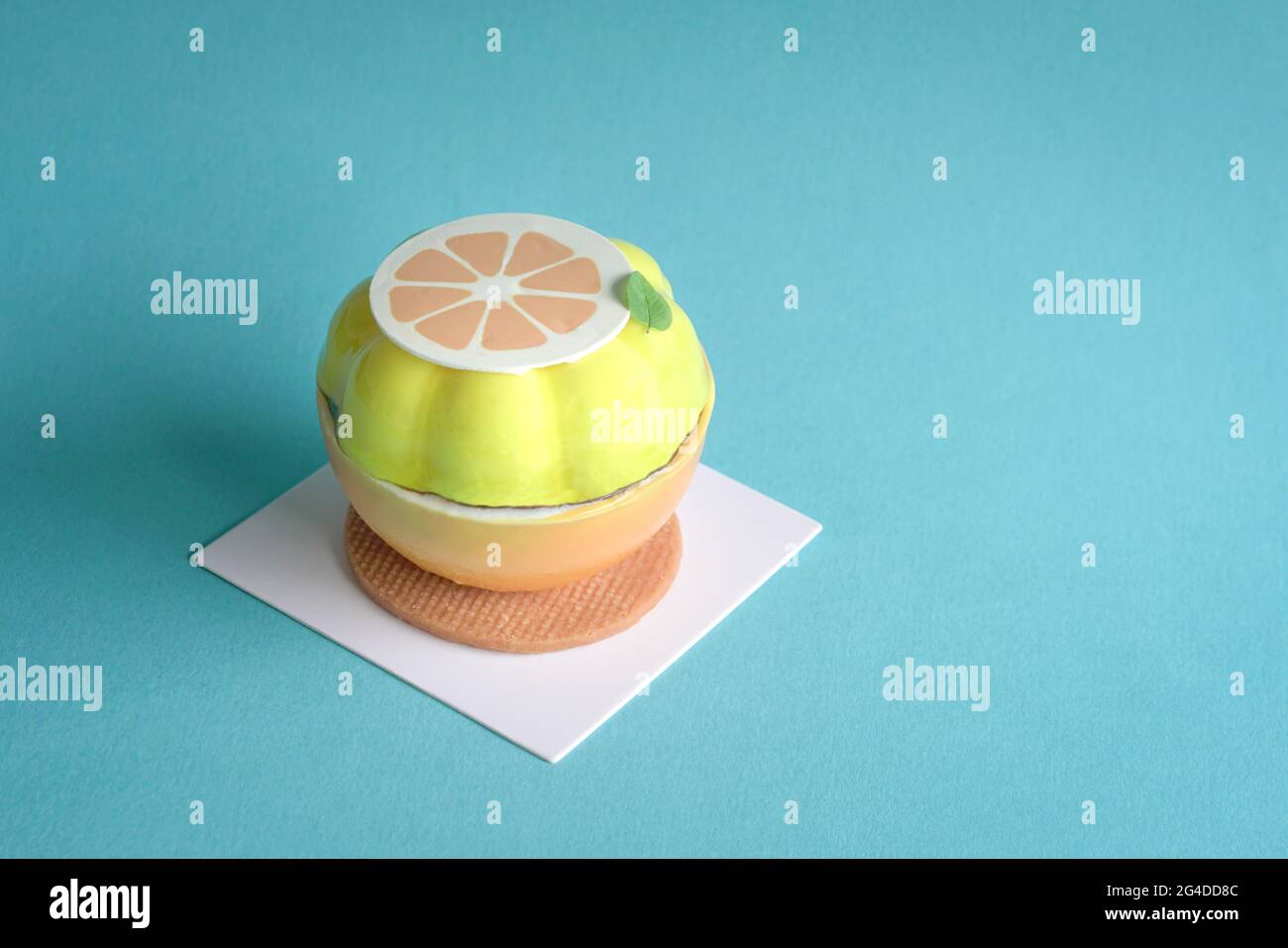 Torta Gatou sotto forma e forma di limone tagliato con base di wafer. Su sfondo blu, spazio di copia. Foto Stock