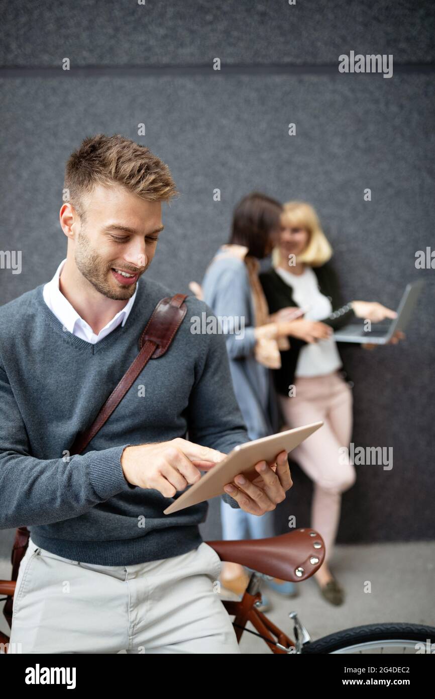 Gruppo di persone aziendali che utilizzano dispositivi elettronici all'aperto Foto Stock