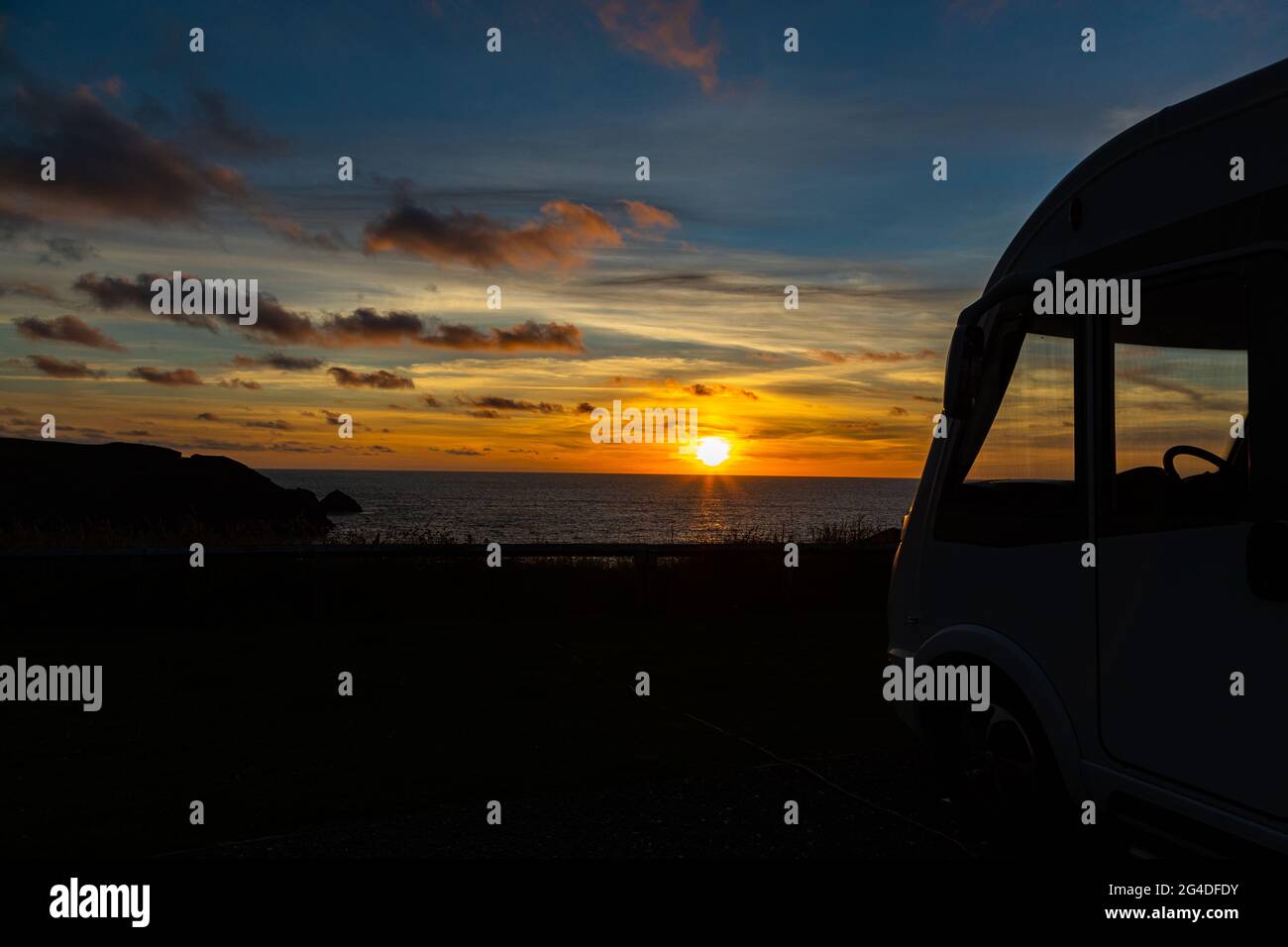 Bella ora d'oro tramonto estivo accanto a un camper camper camper che guarda al mare in Cornovaglia Inghilterra Regno Unito Foto Stock