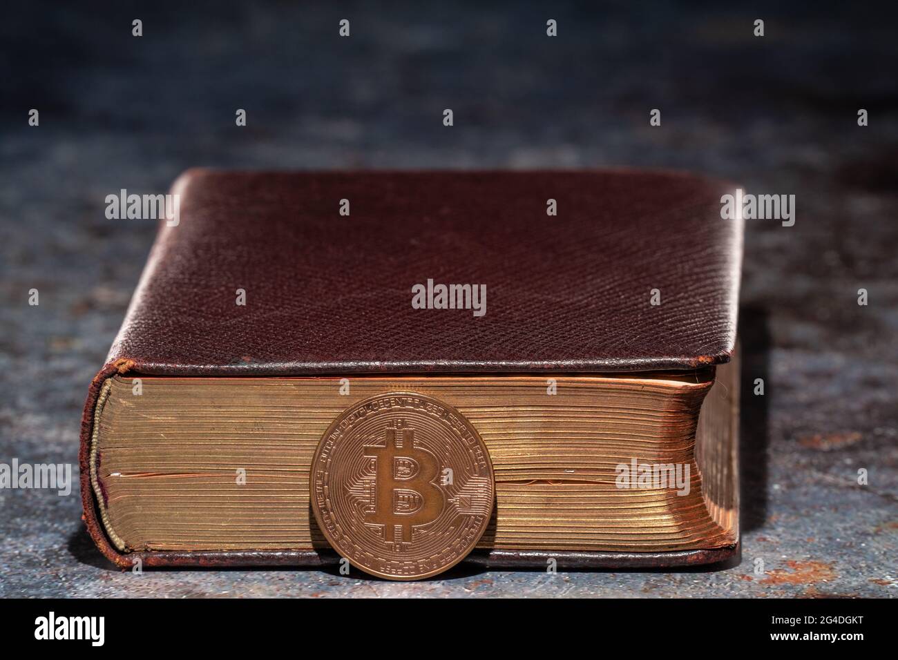 Un vecchio libro con il bitcoin che si trova accanto ad esso. Concetto di conoscenza della criptovaluta Foto Stock