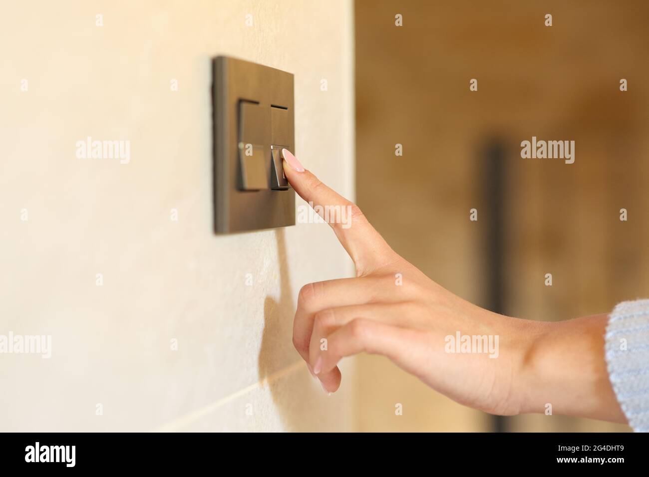 Primo piano di una mano donna che spinge l'interruttore luce a casa Foto  stock - Alamy