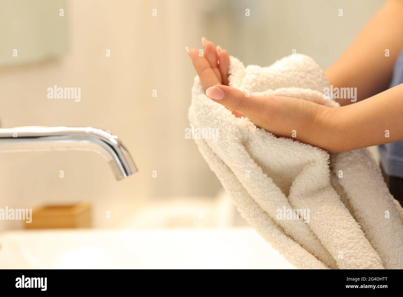 Primo piano di una donna che asciuga le mani con un asciugamano in bagno  Foto stock - Alamy