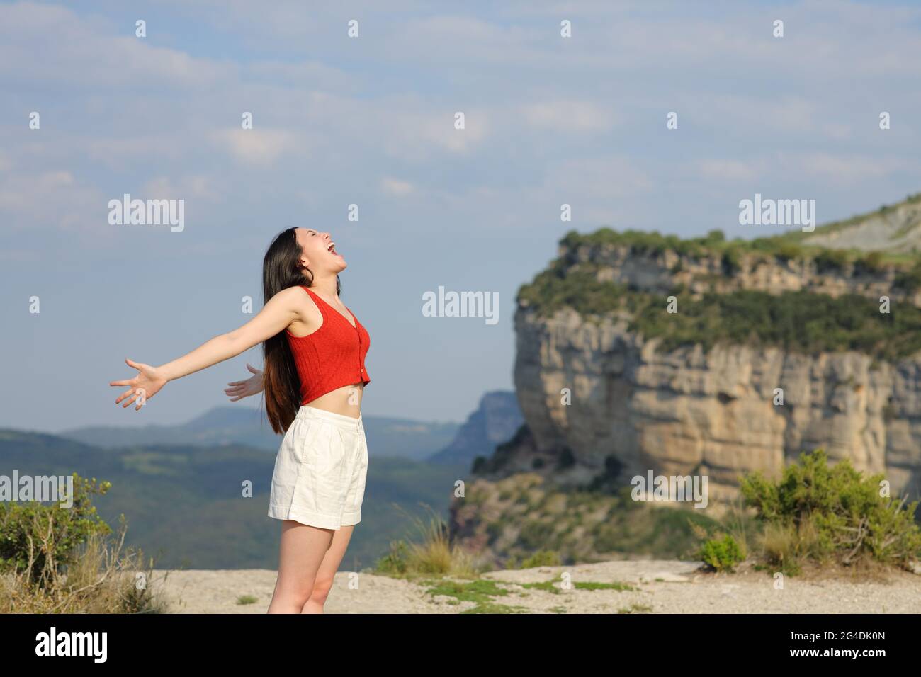 Profilo di una donna di razza mista urlando all'aria sulla cima di una scogliera nel poountain Foto Stock