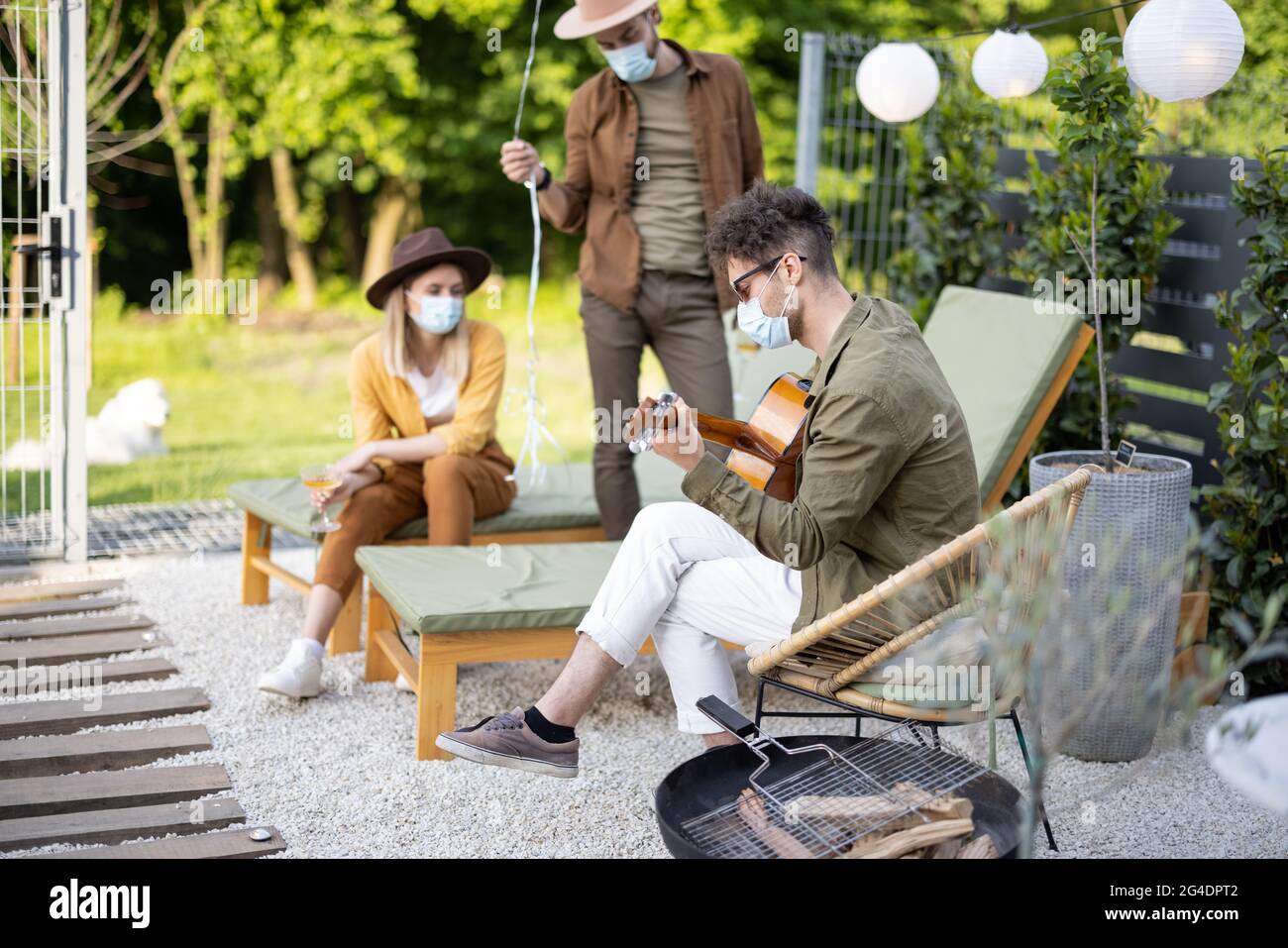Amici in maschera di faccia che celebrano all'aperto Foto Stock