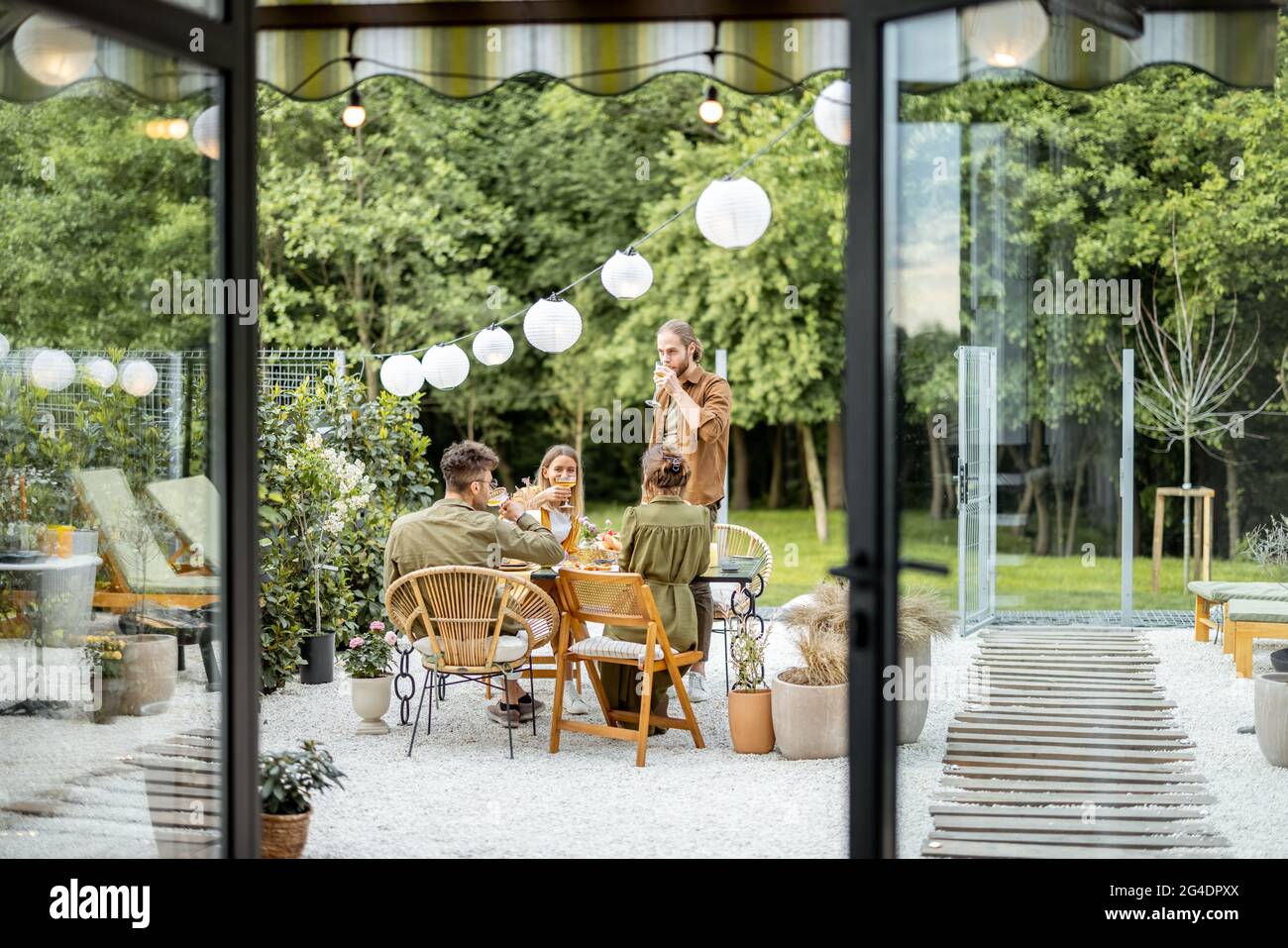 Amici che hanno una cena festosa in cortile Foto Stock