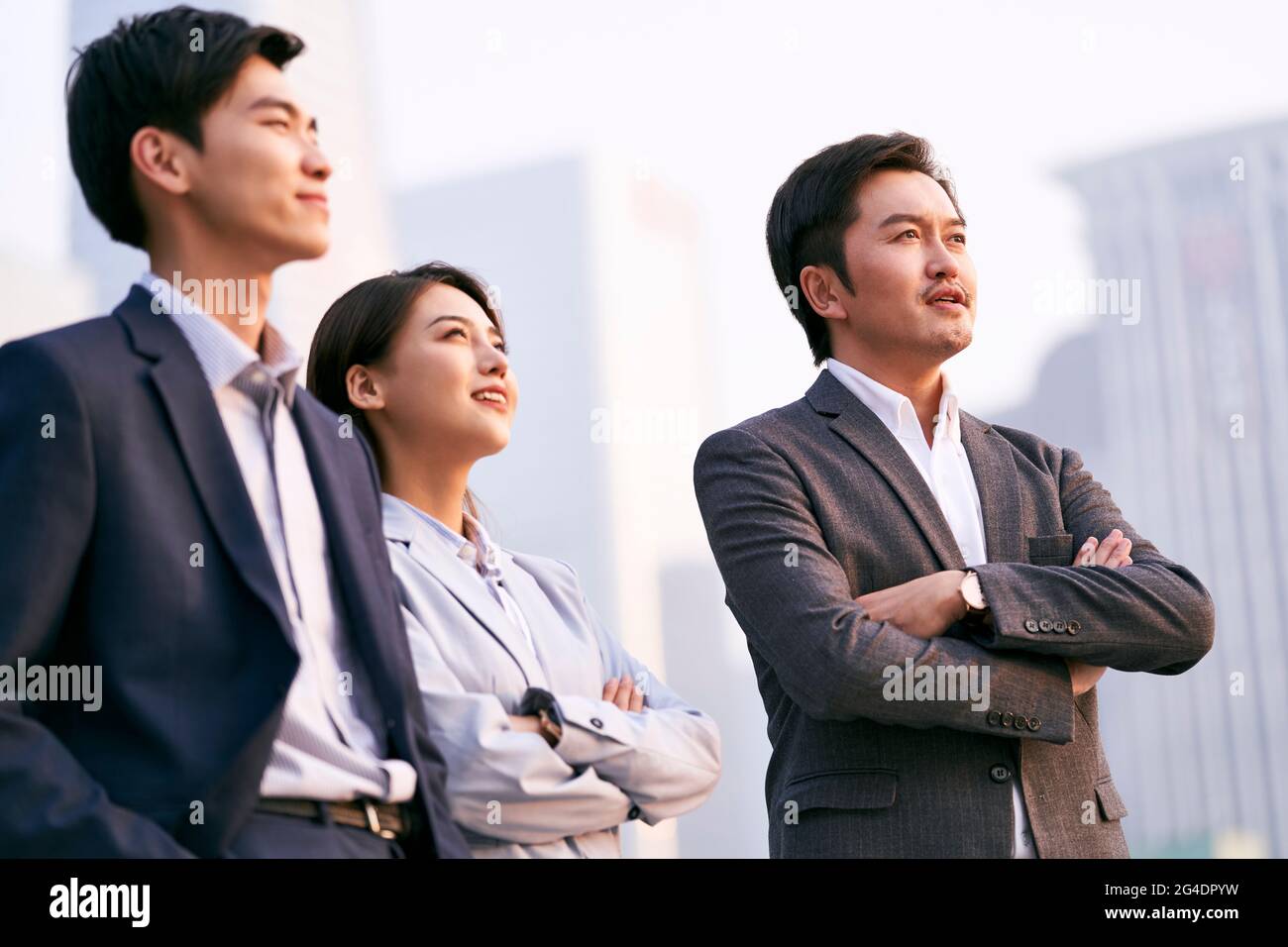 un team di tre uomini d'affari asiatici che parlano parlando di affari all'aperto Foto Stock