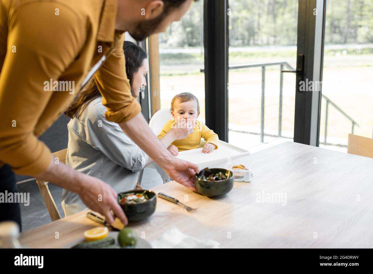 Una giovane famiglia con un bambino durante il pranzo a casa Foto Stock