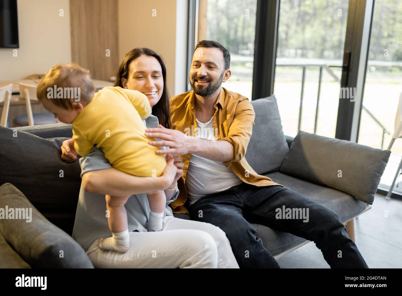 L'uomo lavora da casa con la moglie e il figlio piccolo Foto Stock