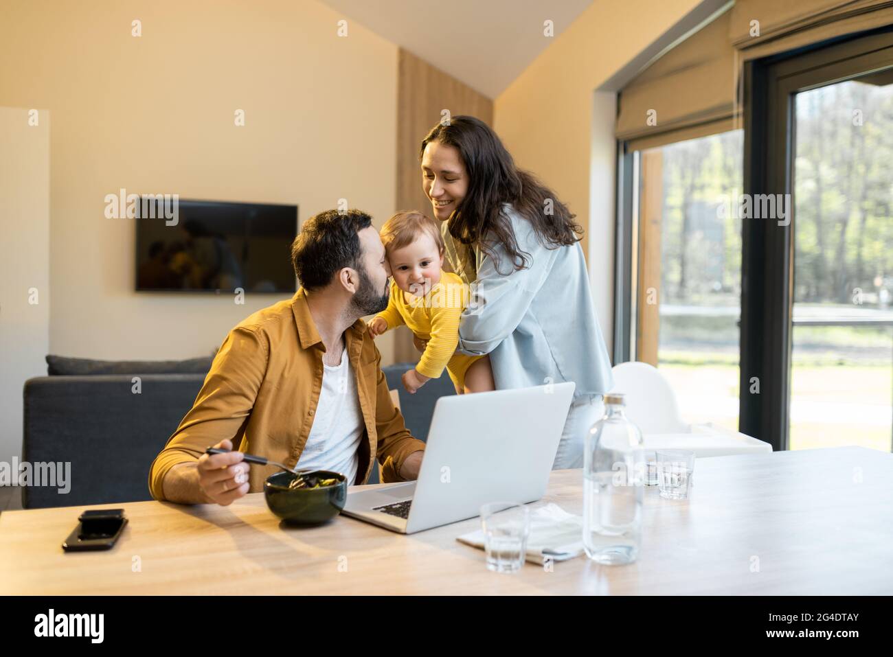 Padre lavora da casa con la sua famiglia Foto Stock