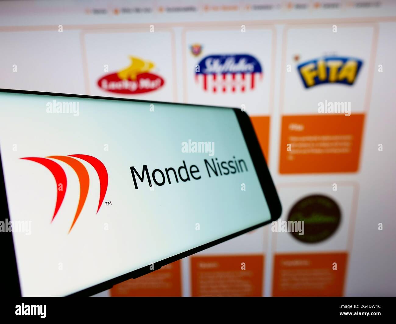 Telefono cellulare con logo della società filippina alimentare Monde Nissin Corporation sullo schermo di fronte al sito web. Mettere a fuoco al centro-sinistra del display del telefono. Foto Stock