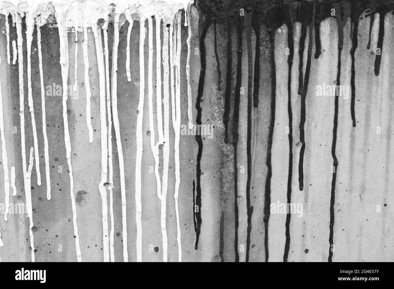 Fotografia di stock di grunge bianco-nero. Vernice bianca e nera che scorre sulla pietra. Parete in pietra grigia con macchie di vernice. Astratto brodo grigio ba Foto Stock