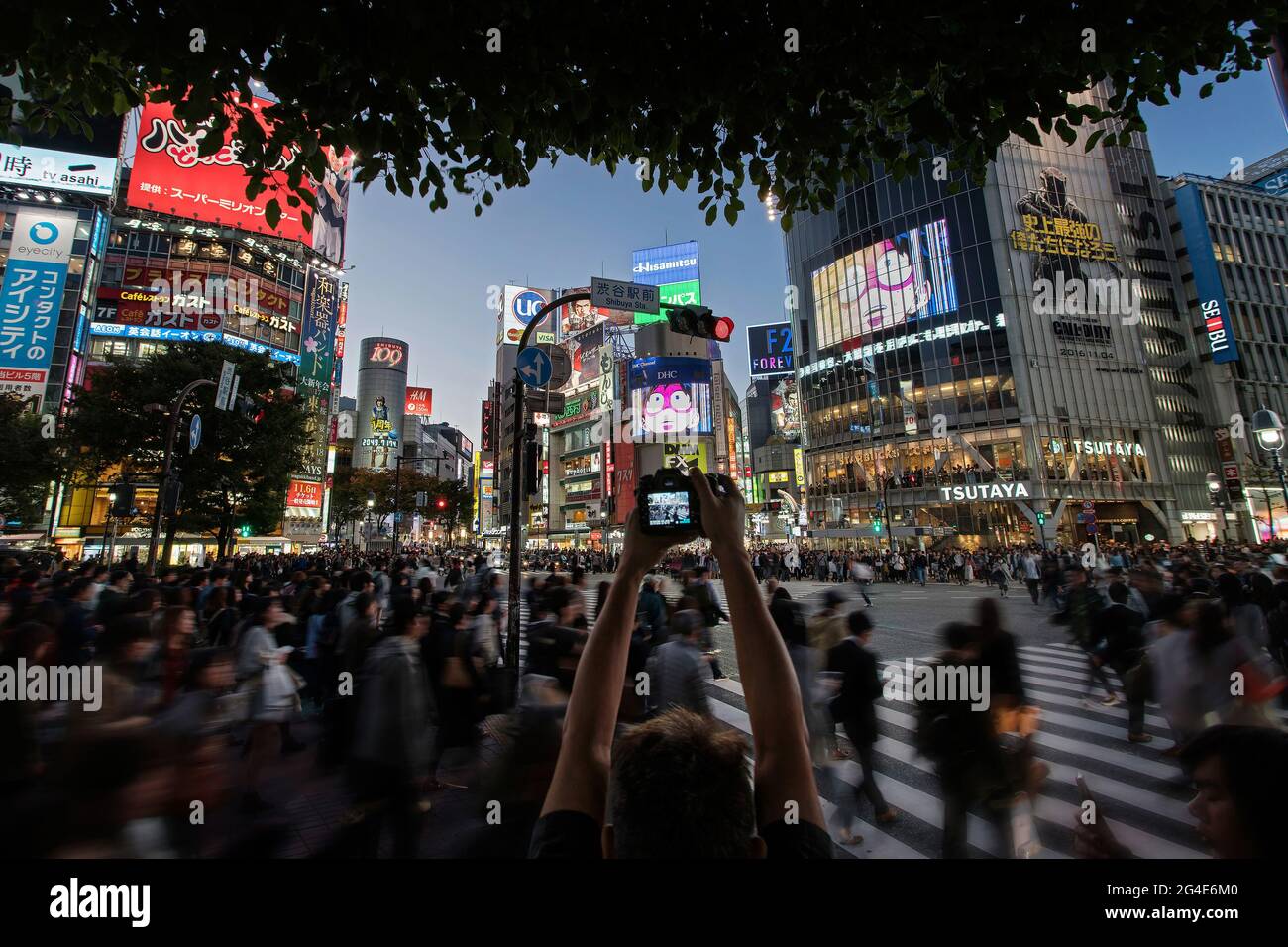 Un uomo che fotografa persone allo Shibuya Scramble Crossing di Tokyo, Giappone Foto Stock