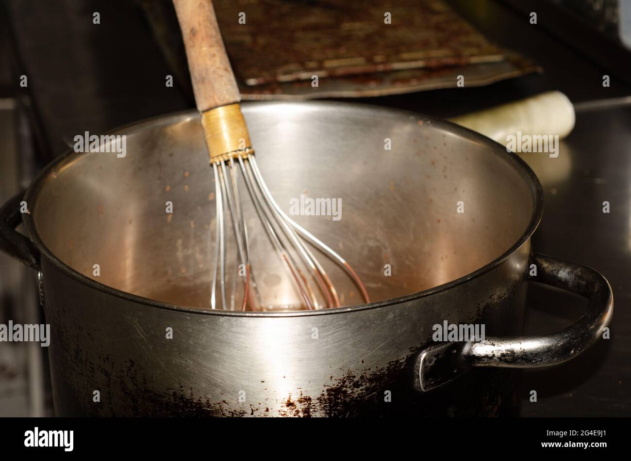 Un primo piano di metallo frusta su una pentola in cucina Foto stock - Alamy