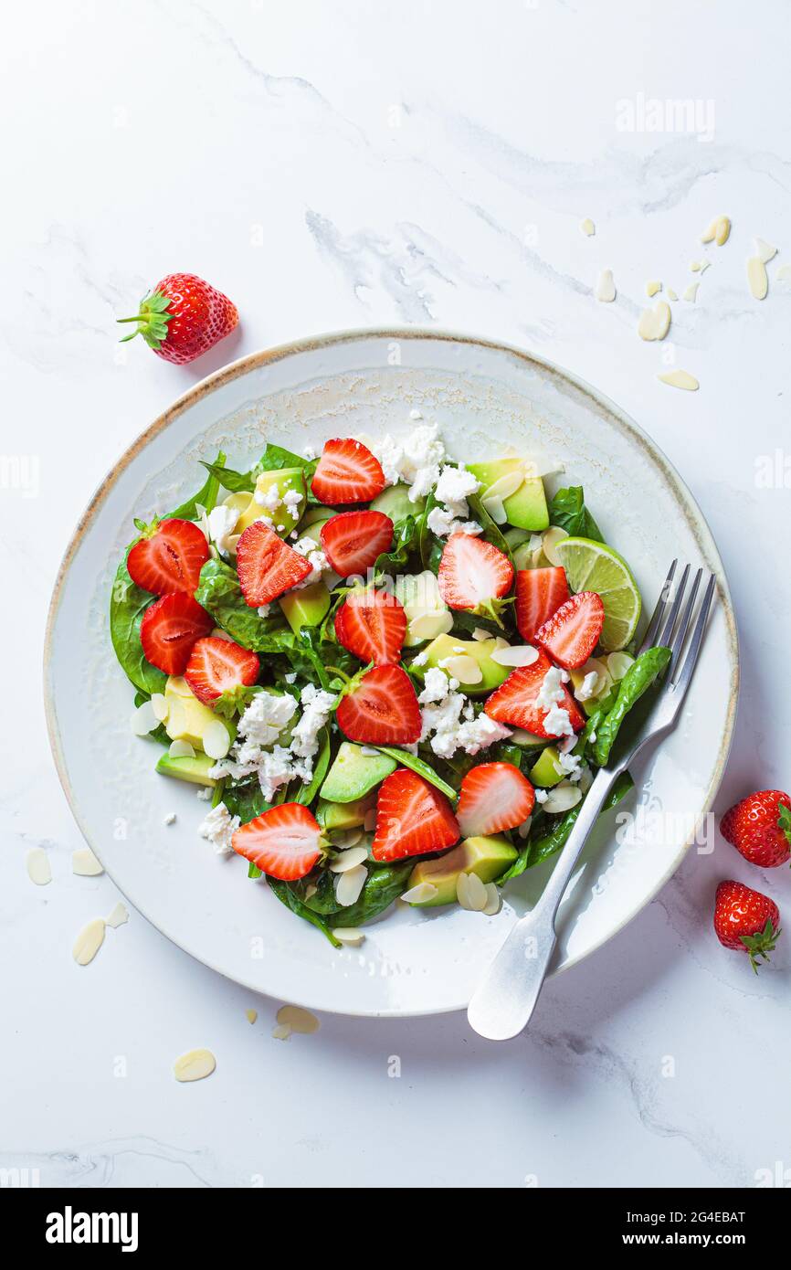 Insalata di fragole con spinaci, formaggio feta, avocado e mandorle. Concetto di cibo estivo. Foto Stock