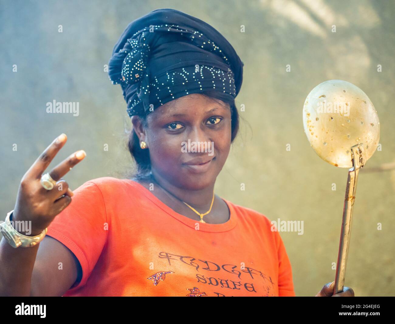MBOUR, SENEGAL - CIRCA GENNAIO 2021. senegalese non identificato donna abbastanza matura in abito tradizionale all'aperto guardando sorridente. Povertà e happine Foto Stock