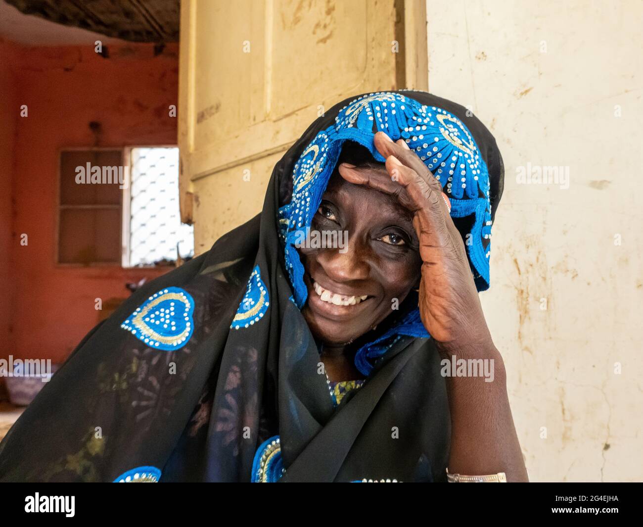 MBOUR, SENEGAL - CIRCA GENNAIO 2021. senegalese non identificato donna abbastanza matura in abito tradizionale all'aperto guardando sorridente. Povertà e happine Foto Stock
