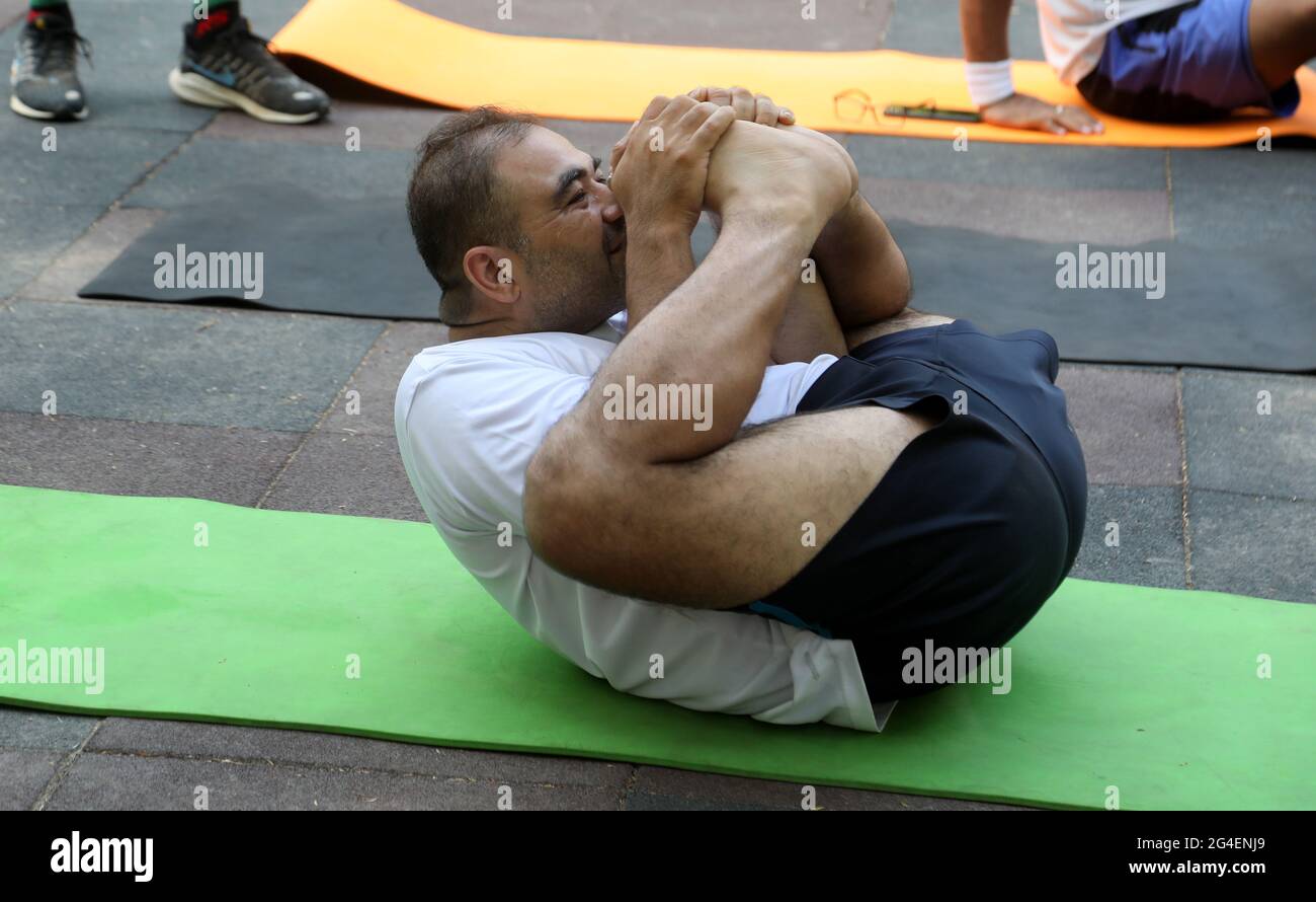 Un uomo esegue posture di yoga per celebrare la Giornata Internazionale  dello Yoga durante la pandemia del coronavirus al District Park.Yoga Day è  celebrato in tutto il mondo per evidenziare l'importanza dello