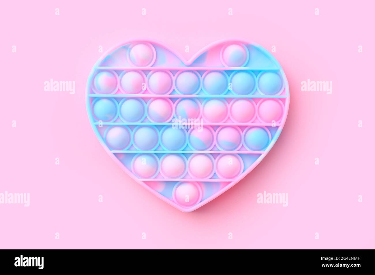 Colorato antistress sensoriale fidget giocattolo spingere in forma di cuore su sfondo rosa, vista dall'alto Foto Stock