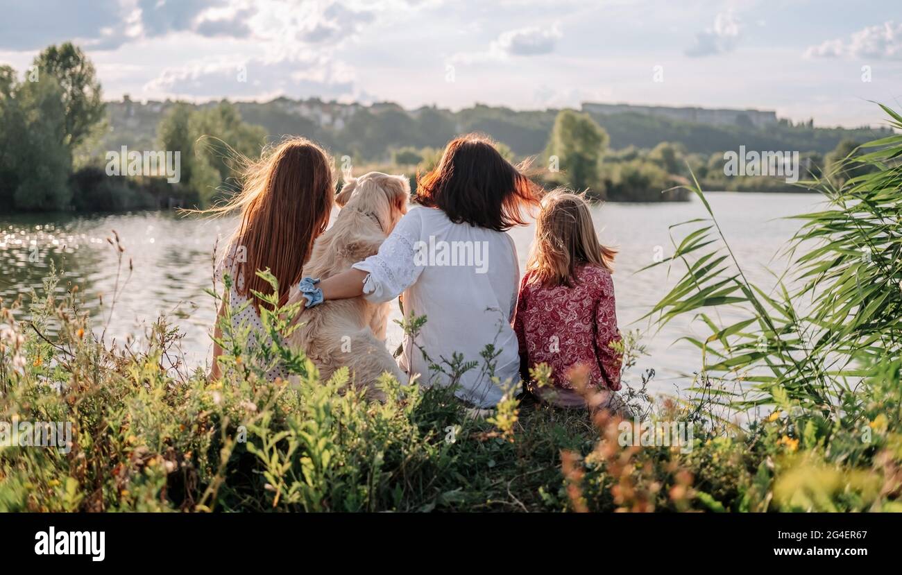 Famiglia con Golden Retriever cane all'aperto Foto Stock
