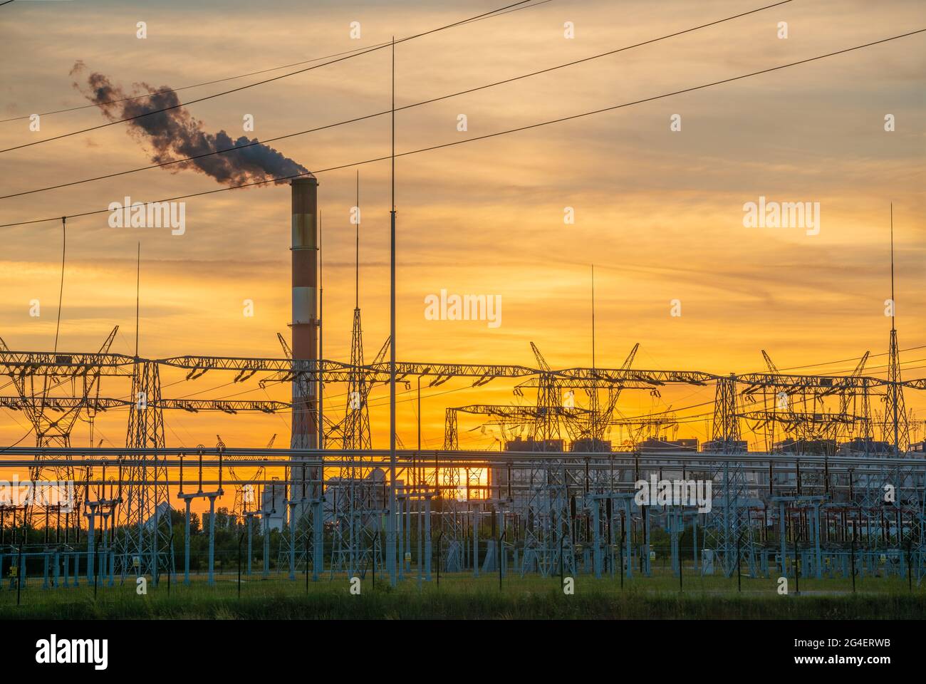 Centrale elettrica, stazione di trasformazione, piloni ad alta tensione sullo sfondo del cielo serale Foto Stock