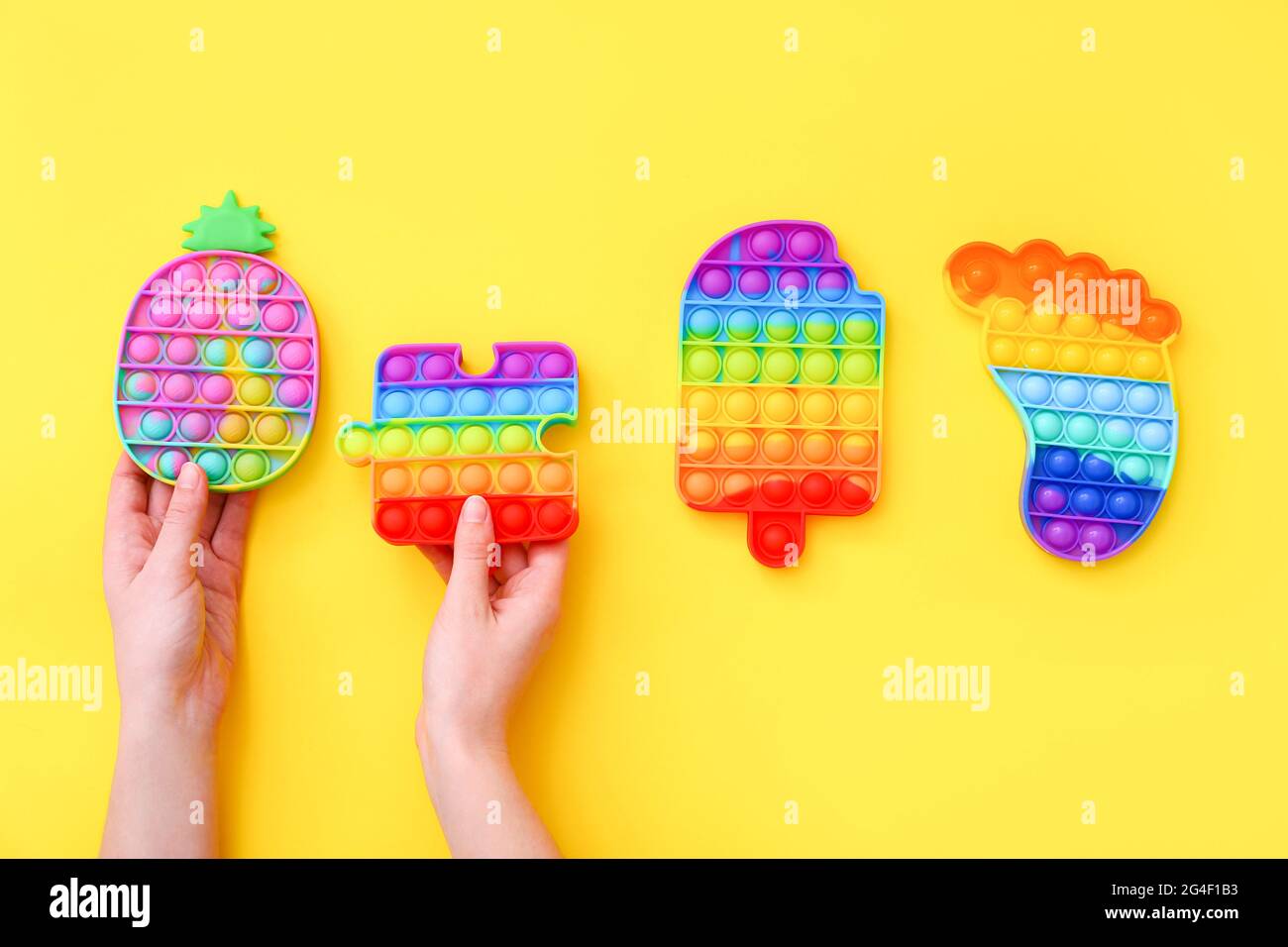 Colorful Push Pop IT Bubble Sensory Fidget Giocattoli di diverse forme su sfondo giallo Foto Stock