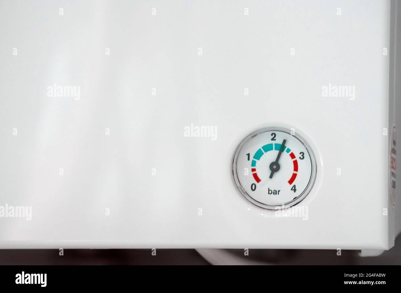 Scala di pressione con una freccia sulla parete di un riscaldatore dell'acqua bianco, primo piano Foto Stock