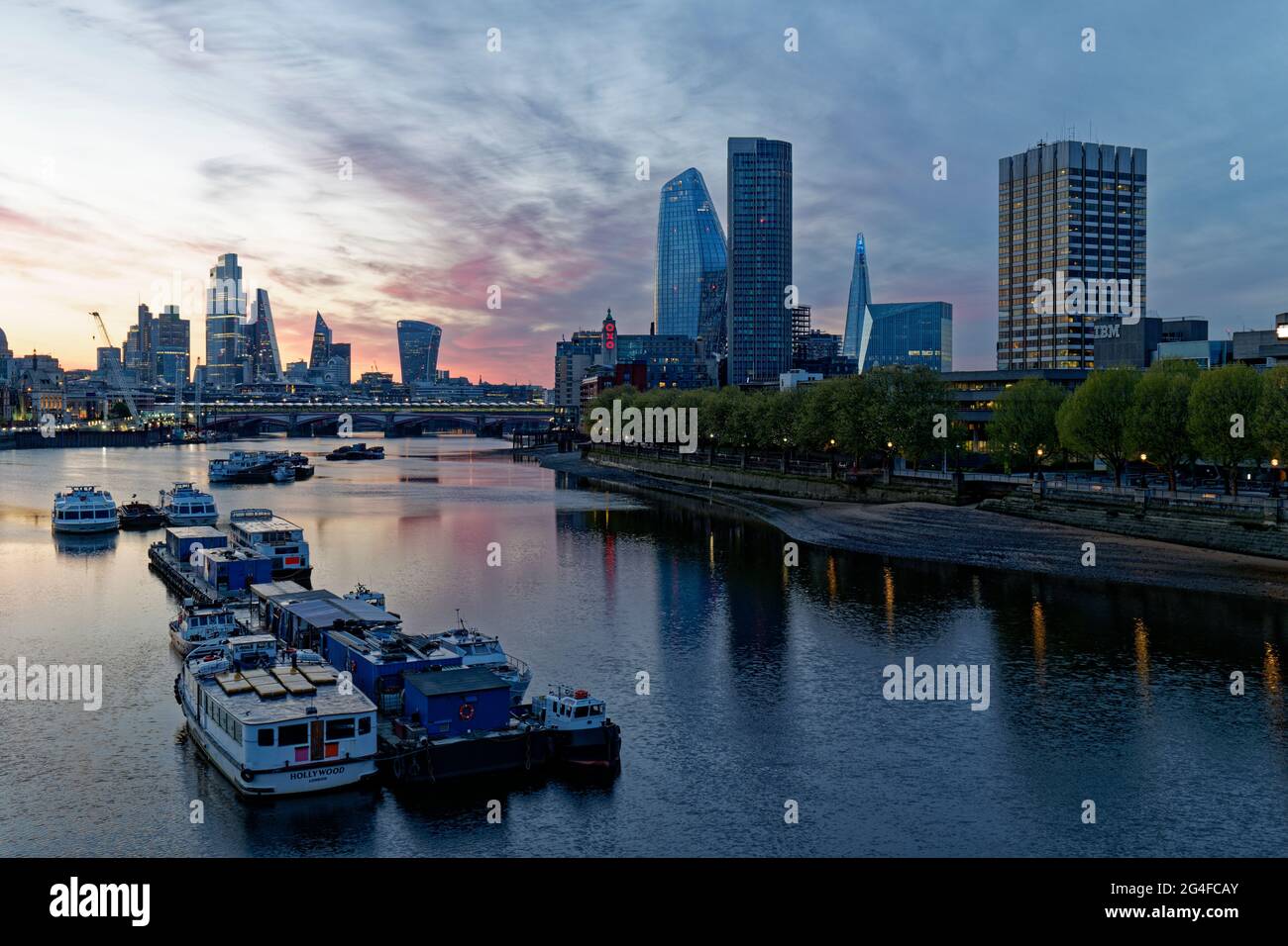 La luce dell'alba sul Tamigi a Londra, in Inghilterra, rivela il centro finanziario della città e i molti nuovi edifici di alto livello Foto Stock