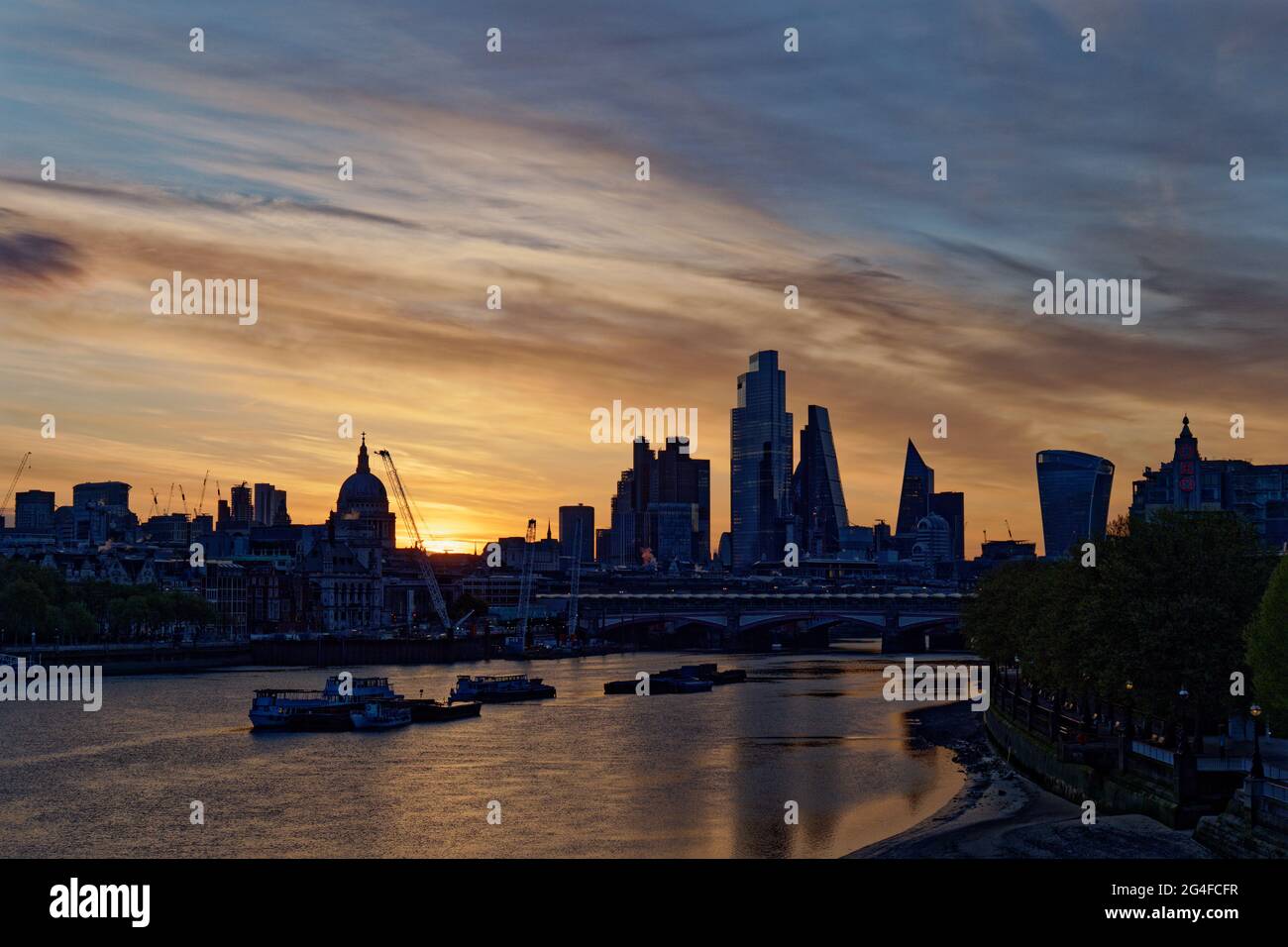 La luce dell'alba sul Tamigi a Londra, in Inghilterra, rivela il centro finanziario della città e i molti nuovi edifici di alto livello Foto Stock