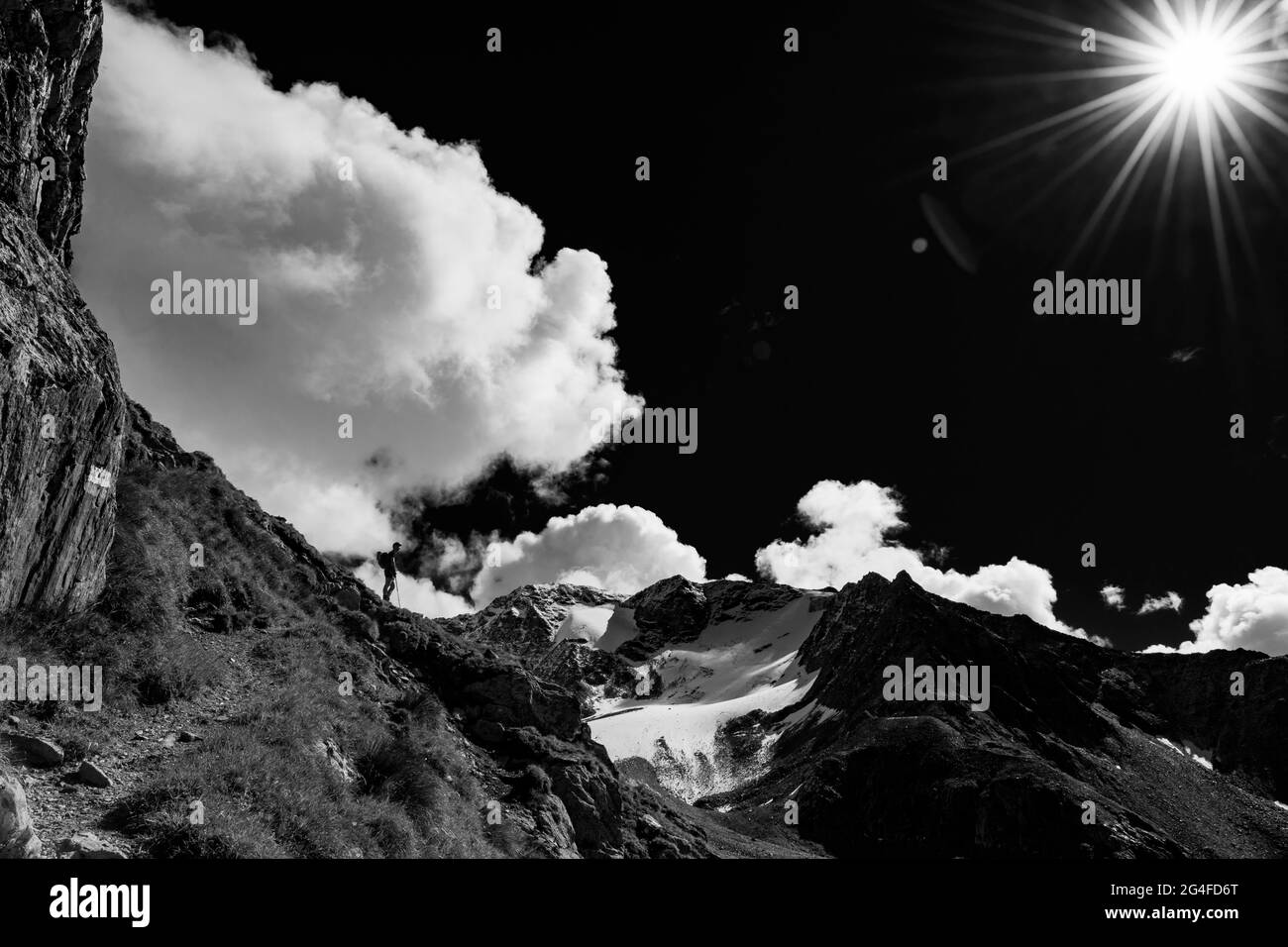 Alpinista in controluce e cielo nuvoloso con le Alpi Oetztal Soelden, Oetztal, Tirolo, Austria Foto Stock