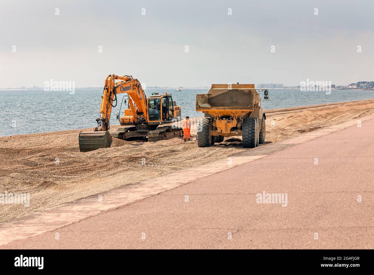 Operai che completano le difese contro le alluvioni sulla parata del Principe Hythe, sulla spiaggia, Kent. Foto Stock