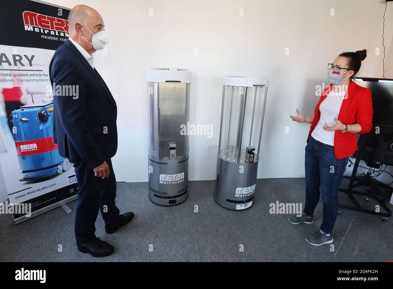 Ilmenau, Germania. 21 Giugno 2021. Wolfgang Tiefensee (SPD), (l) Ministro dell'Economia in Turingia ottiene un prototipo del robot di disinfezione a luce UV-C contro Corona spiegato da Sabrina Greul-Nothnagel, ingegnere commerciale, durante la visita della società MetraLabs GmbH. Credit: Bodo Schackow/dpa-Zentralbild/dpa/Alamy Live News Foto Stock