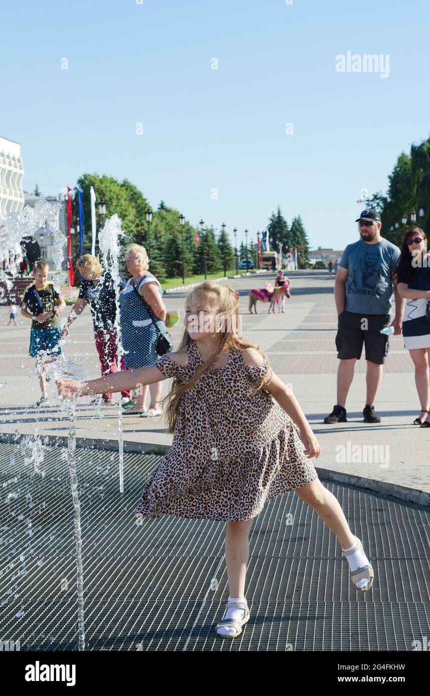 Persone alla fontana, calore anormale in Russia. La ragazza gode i flussi freddi di acqua. Ulyanovsk, Russia, 19 giugno 2021 Foto Stock