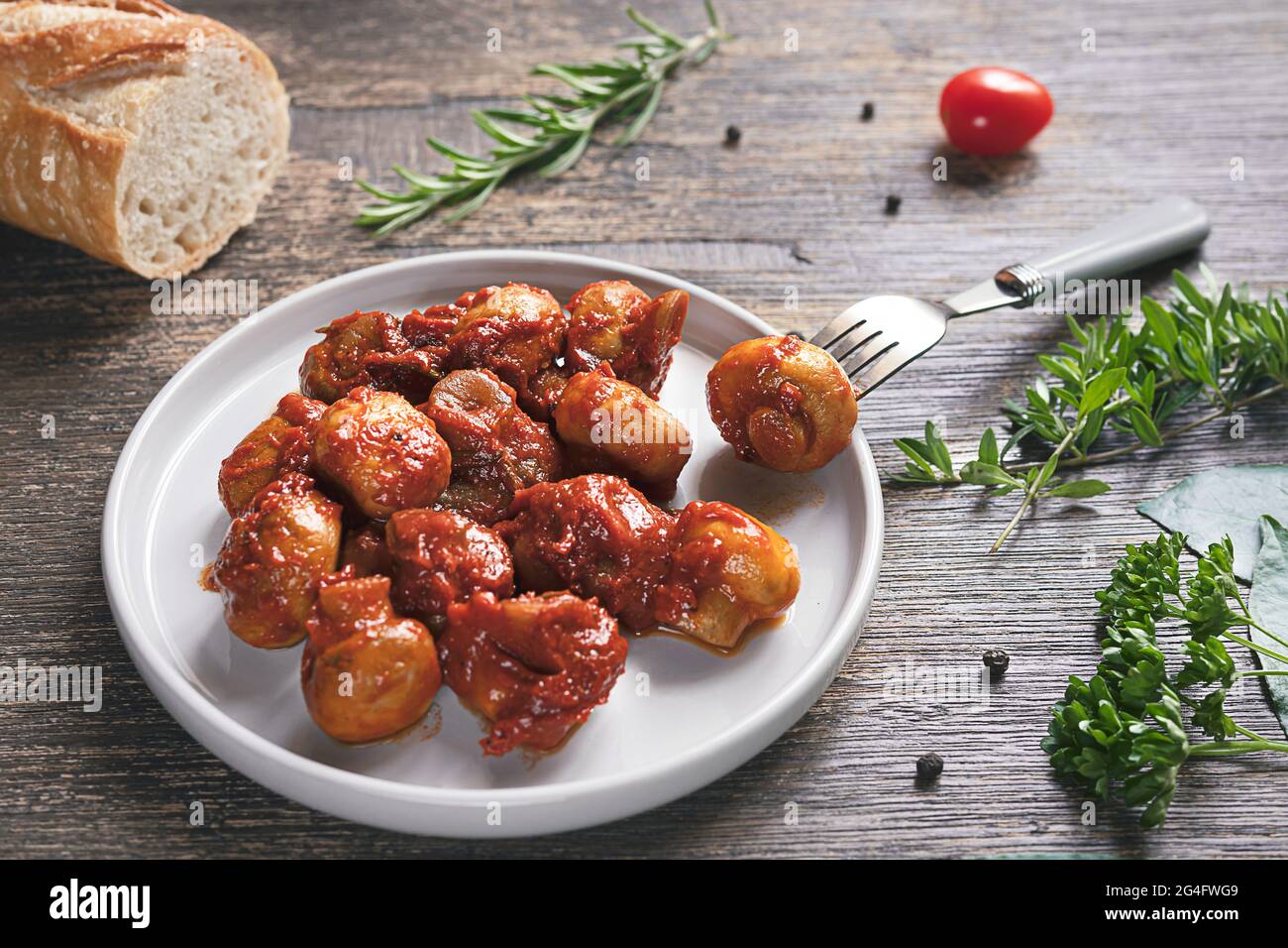 Un piatto con funghi, pane, condimenti e spezie in stile greco su sfondo di legno scuro Foto Stock