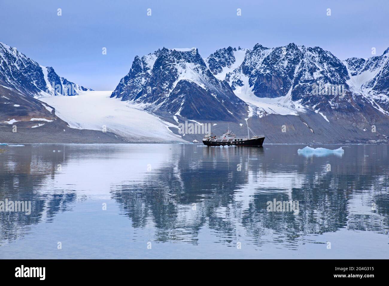 Spedizione nave / spedizione yacht MV Togo e le montagne frastagliate lungo Magdalenefjorden, Albert i Land, Svalbard / Spitsbergen, Norvegia Foto Stock