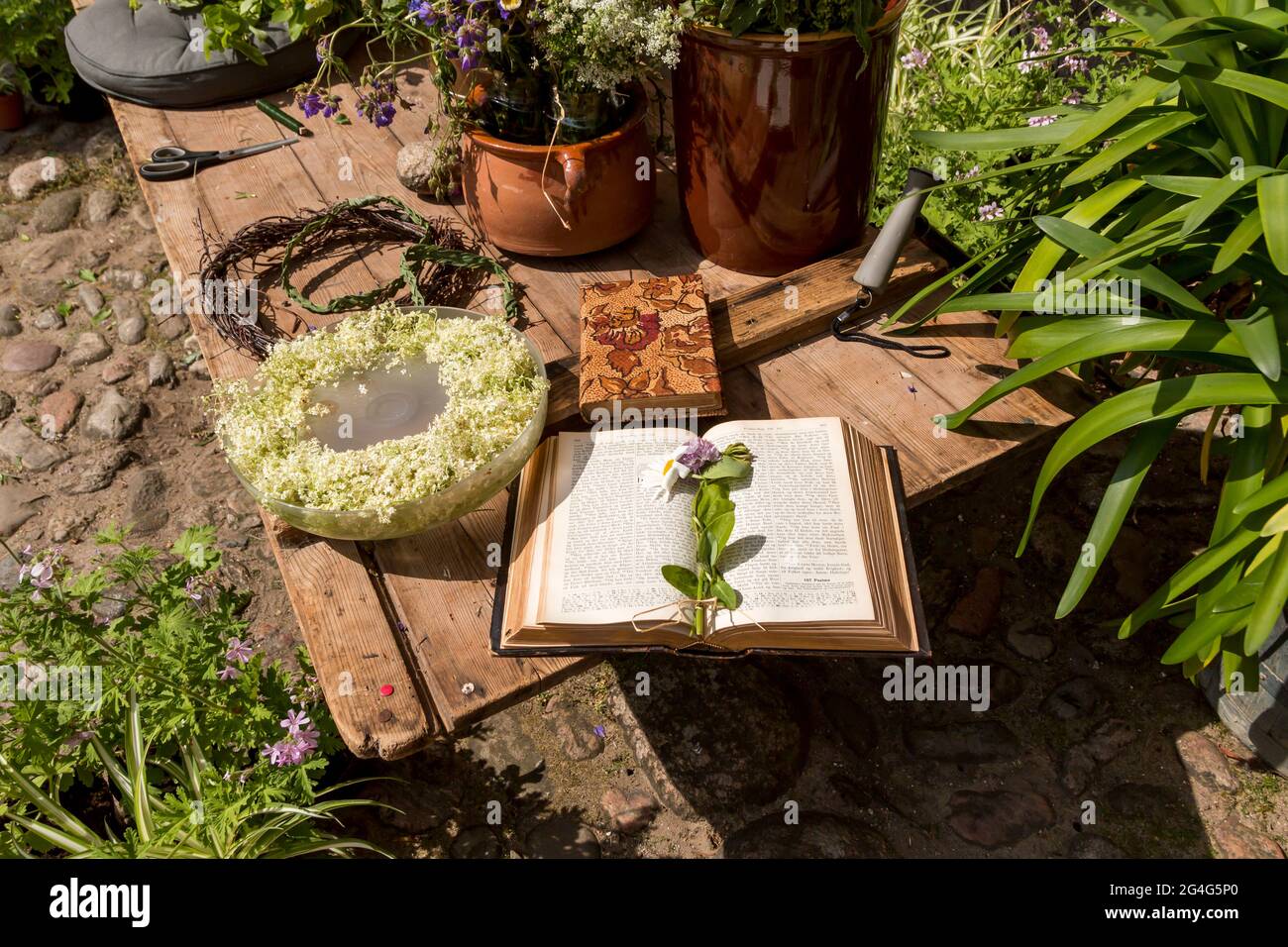 Auning, danimarca - 19 giugno 2021: Giornata del XVIII secolo al castello di Gammel Estrup, i fiori usavano legare le corone di fiori, un libro sulla panchina Foto Stock