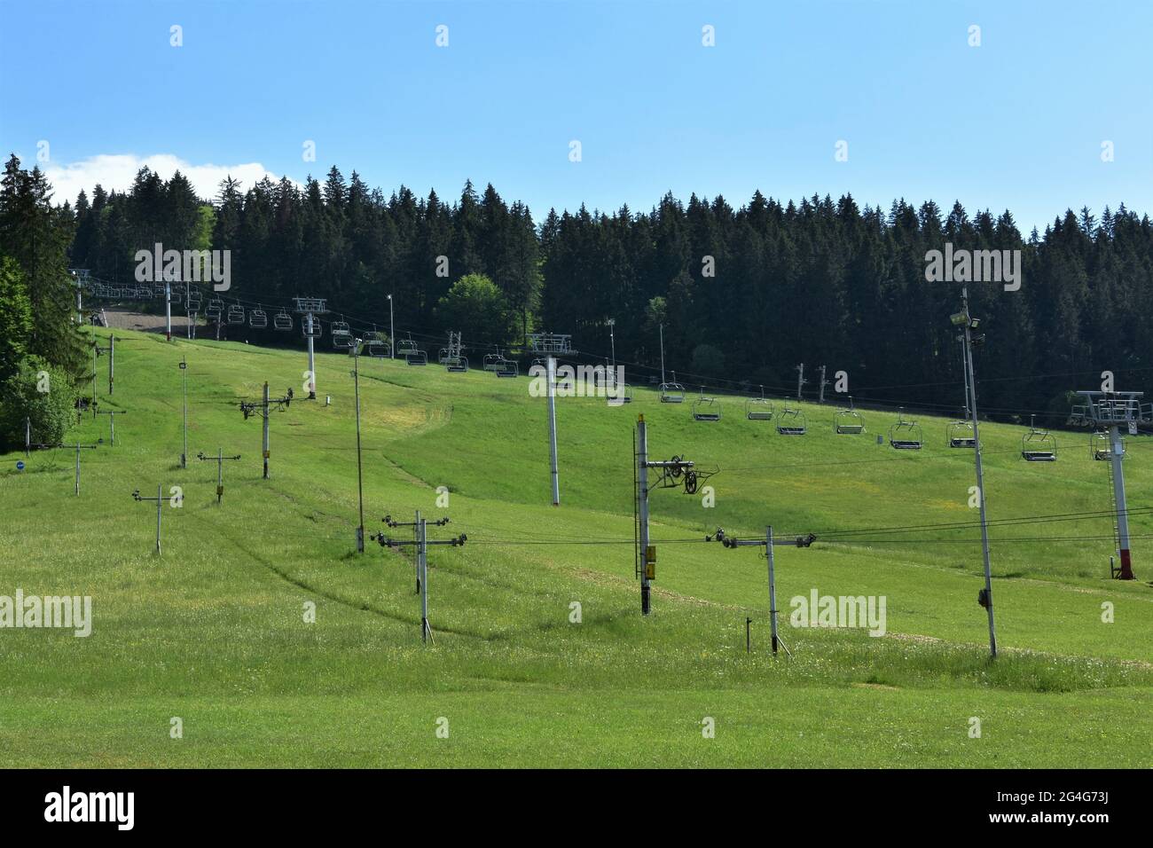 Area sciistica abbandonata, Jasenska dolina, con impianti di risalita situati nella regione Turiec, in Slovacchia, durante l'estate. La collina è coperta di erba verde. Foto Stock