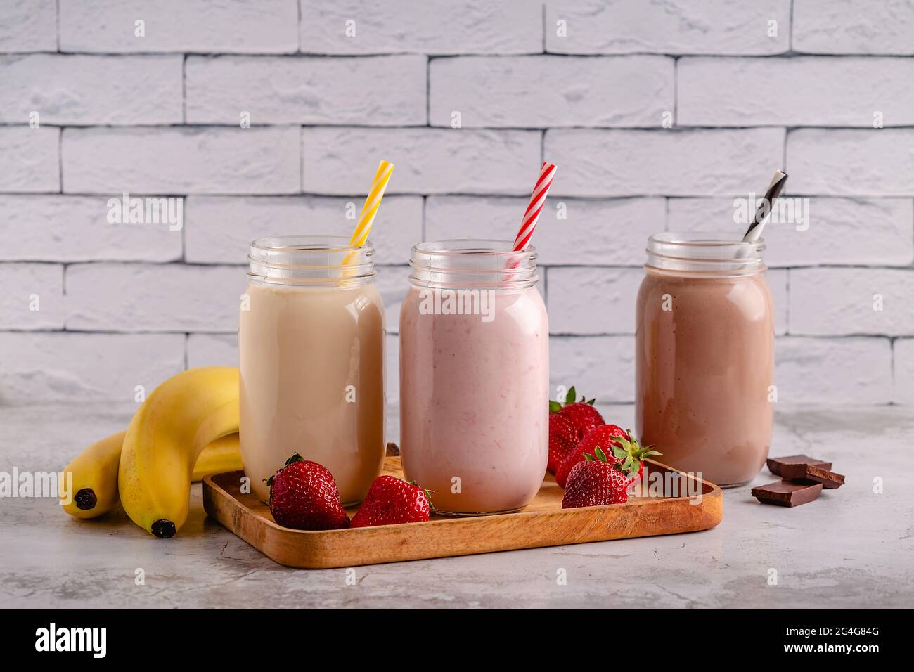 Set di fragole banana e cioccolato milkshake nei vasi di vetro Foto Stock