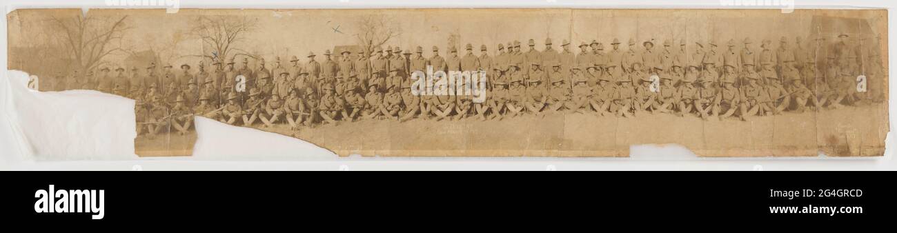 D Company, 369° reggimento a Camp Merritt, New Jersey durante la prima guerra mondiale, di proprietà della CPL. Lawrence McVey. Gli uomini indossano uniformi militari e alcuni uomini in prima fila tengono i fucili. Il corporale Lawrence McVey ha servito con la 369a compagnia di fanteria D durante la prima guerra mondiale, combattendo nelle battaglie di Champagne-Marne difensiva, Mosa-Argonne offensiva, D& n ° x2019; Afrique e Calvin difensivo sectore. A causa della tensione razziale all'interno dell'esercito americano, il 369° Reggimento di fanteria fu assegnato all'esercito francese per la durata del coinvolgimento degli Stati Uniti nella prima Guerra Mondiale, formato dalla 15° Natia di New York Foto Stock