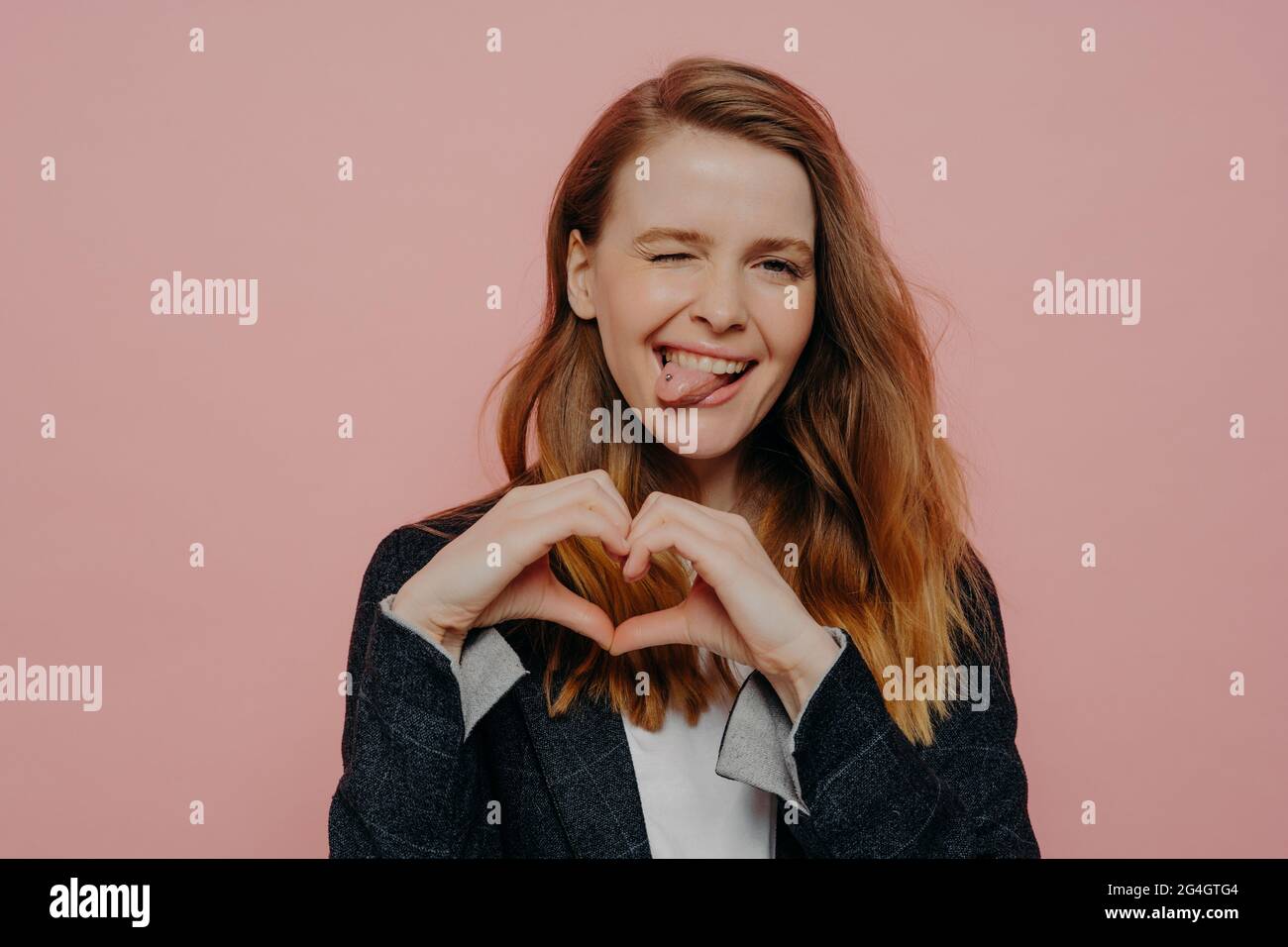 Felice giovane donna eccitata che mostra il segno della forma del cuore Foto Stock