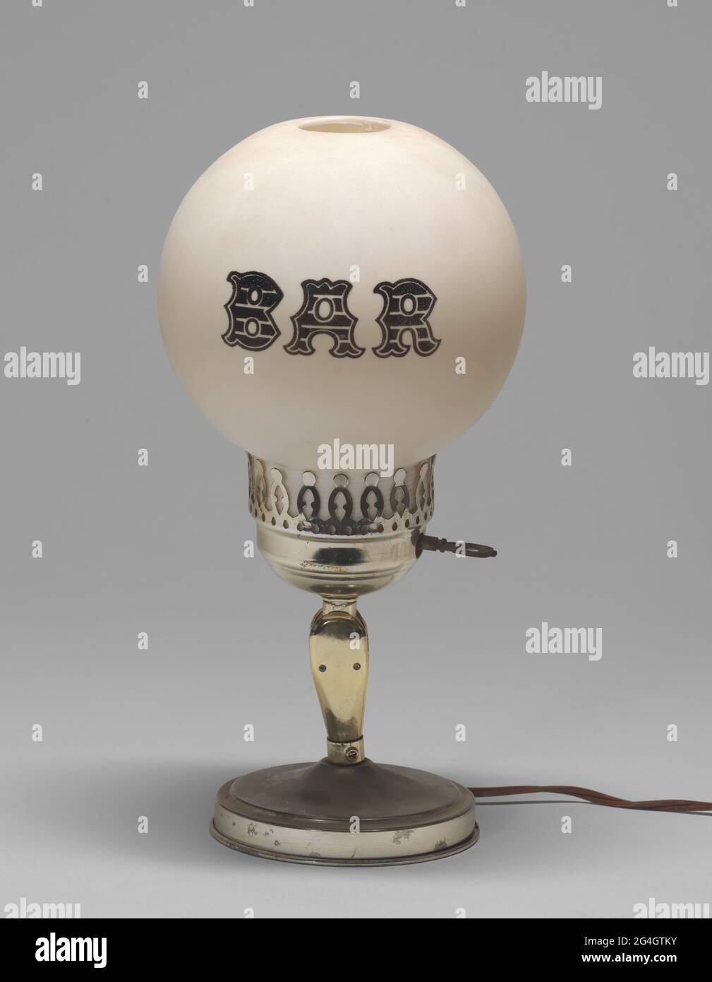 Una lampada elettrica con la parola "BAR" stampata sul paralume della  lampada. Il paralume della lampada ha una forma a sfera ed è realizzato in  plastica trattata per apparire come vetro smerigliato.
