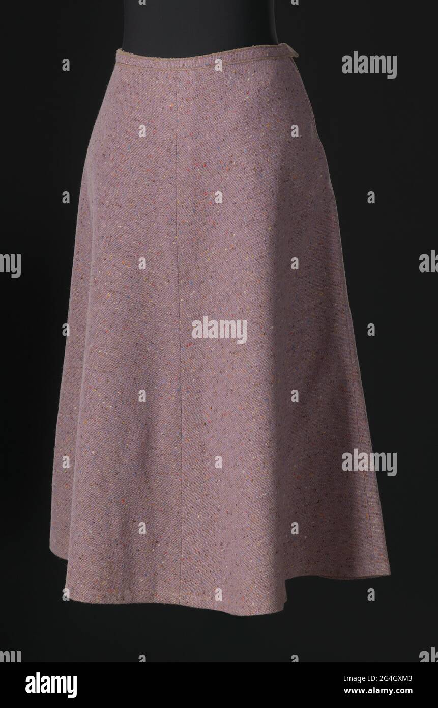 Gonna A-line in tweed di lana di lavanda disegnata da Arthur McGee. La gonna è dotata di una sottile cintura e cade appena sotto il ginocchio. Si chiude sul lato sinistro corretto con una cerniera e due (2) ganci metallici negli anelli filettati. Il tessuto presenta delle macchie multicolore. La gonna non è rivestita. Un'etichetta di tessuto color crema con testo ricamato nero è cucita all'interno centrale della vita posteriore che recita "ARTHUR McGee / N.Y.C.". Nel 1957, Arthur Lee McGee (1933-2019) è stato il primo designer afroamericano assunto per gestire uno studio di design sulla settima Avenue nel Garment District di New York City. Foto Stock