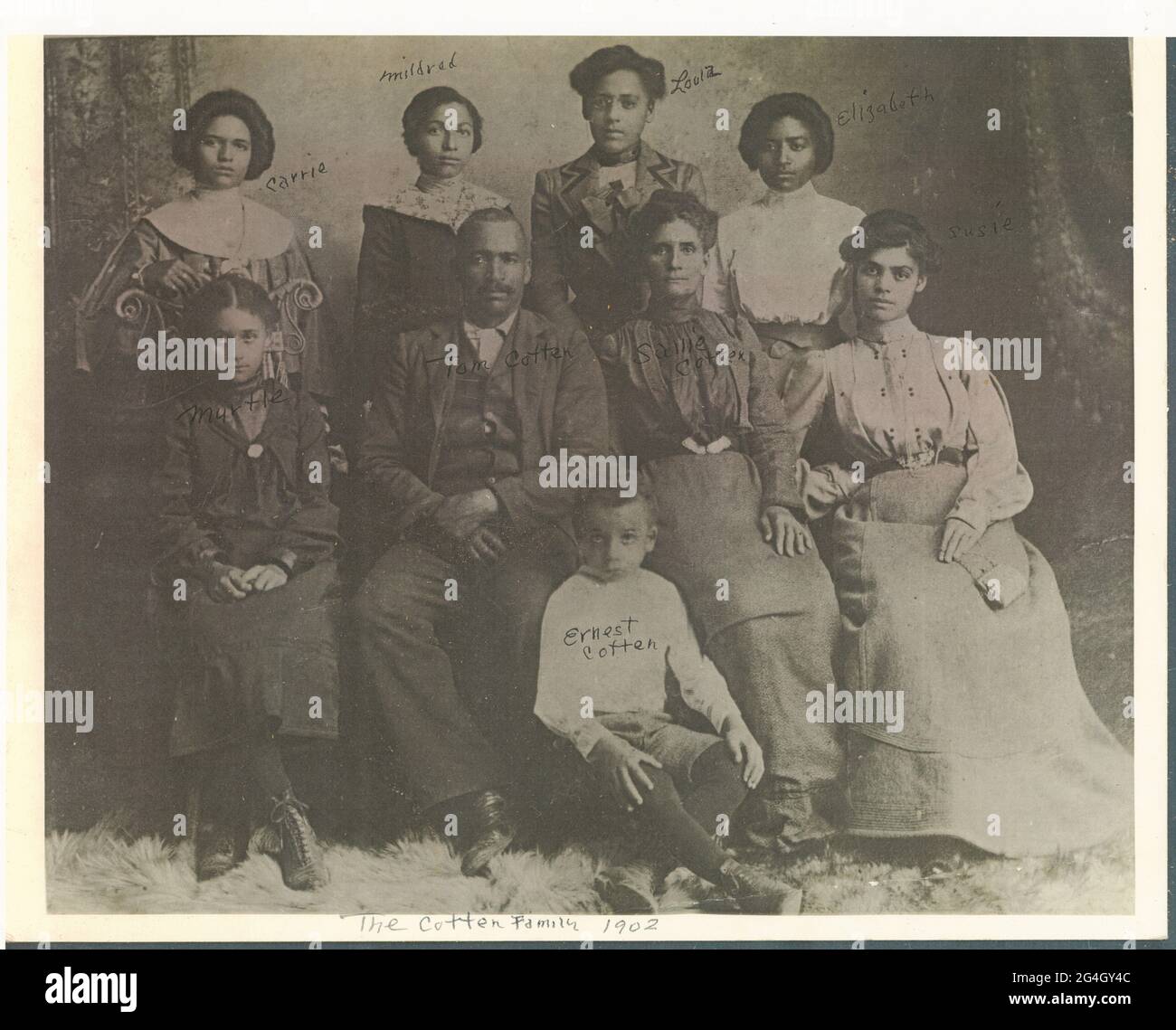 Loula Cotten Williams è raffigurata qui con i suoi genitori e fratelli nella contea di Madison, Tennessee. In seguito si sarebbe ricollocata a Tulsa, Oklahoma, dove lei e suo marito, John Wesley Williams, possedevano e gestiva il Dreamland Theatre. Situato su Greenwood Avenue, il teatro ha mostrato spettacoli musicali dal vivo e teatrali oltre a film silenziosi. Fu distrutta nel massacro di Tulsa Race del 1921. Tutte le persone sono identificate ed etichettate con inchiostro nero. Tom Cotten e Sallie Cotten si siedono al centro con le loro figlie che si siedono e si levano in piedi intorno a loro. Le ragazze sono identificate come (lef Foto Stock