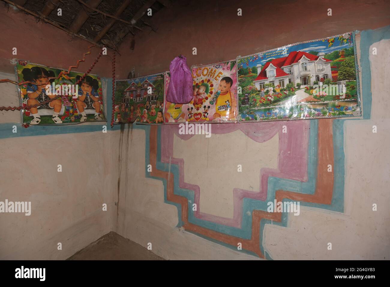 TRIBÙ KOL. Casa - interno della casa decorate pareti con poster. Bhanpur Villaggio di Huzur Tehsil a Rewa Dist, Madhya Pradesh, India Foto Stock